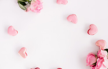 Fototapeta na wymiar pink roses and heart shaped macaroons