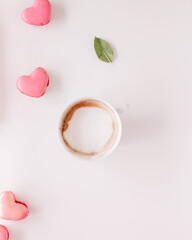 Fototapeta na wymiar Coffee cup on a empty surface with a heart shaped macaroon, pink vibes