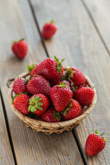 Bowl of red juicy strawberries on rustic wooden table. Healthy and diet snack food concept.