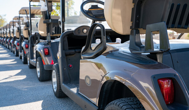 Background image of multiple golf carts parked in order.