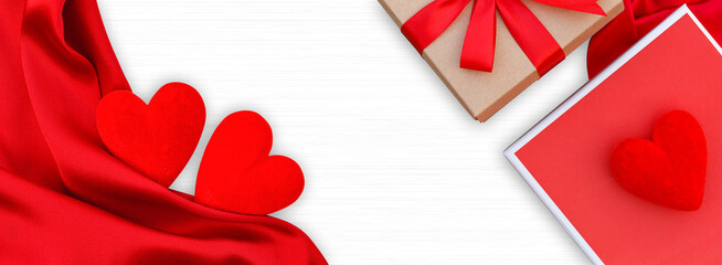 Wooden white background with red hearts, gifts box and red satin. Concept of valentine day