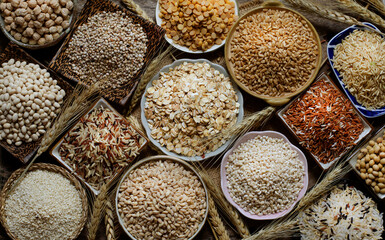Top view of dry organic cereal and grain seeds in wooden and ceramic bowl on sack and grunge background in dark tone, for carbohydrate or healthy food ingredient concept