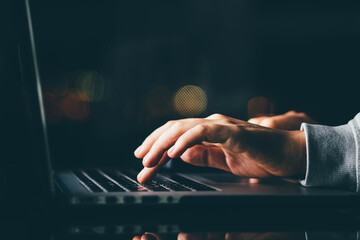 Freelance woman working on laptop at the night. Close up hand with laptop.