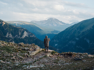 Back view of a man in warm clothes in the mountains in nature