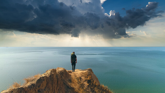 The hiker standing on a mountain against the rainy background - Powered by Adobe