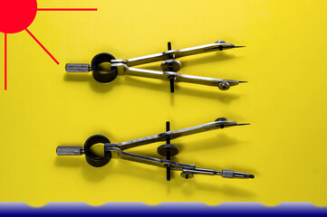 Compasses lying on a background showing the beach, the sea and the sun