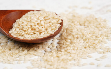 White sesame - Sesamum indicum - seeds in small wooden scoop, closeup detail