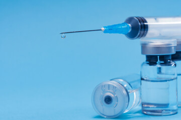 Ampoule, vial bottle, syringe on blue background. Vaccination concept, disease prevention. Health care, Coronavirus vaccine development. Selective Focus