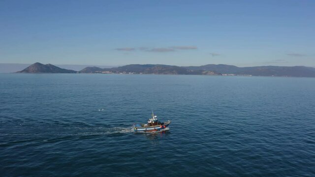 Aerial view of a fishing ship sailing through Galicia Spain