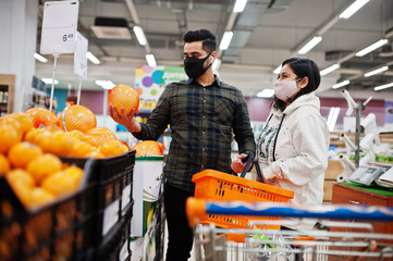 Asian couple wear in protective face mask shopping together in supermarket during pandemic. Choose...