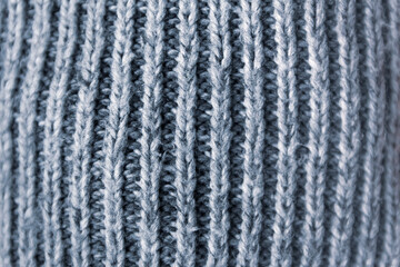 Knitted fabric soft texture close up. Natural grey surface.