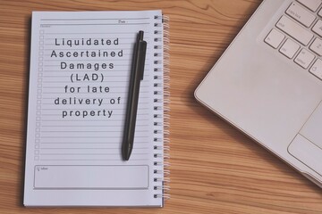 Text label on notepad with laptop on wooden table table