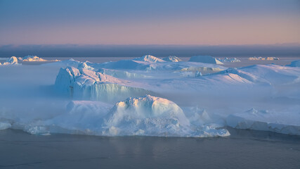 floating glaciers in the rays of the setting sun during a polar night