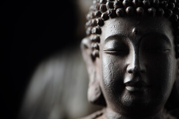 Meditating Buddha Statue on black background.