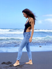 Young woman relaxing on the volcanic beach of the island of Lanzarote