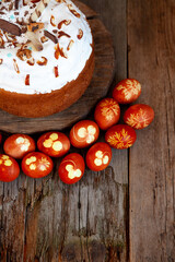 Easter cake and colored eggs. Rustic food on a wooden table. Egg colored with onion peel. Clover and dill leaves pattern. Classic food for the Easter holiday
