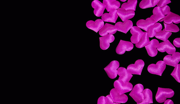  pink volumetric hearts on a black background. scattering of small hearts. High quality photo