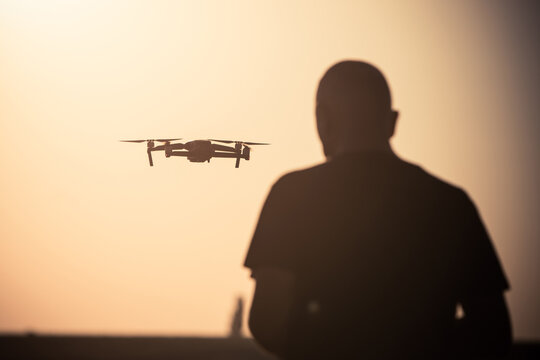Man flying a drone at sunrise