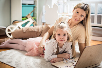 Mother and daughter using laptop together. 