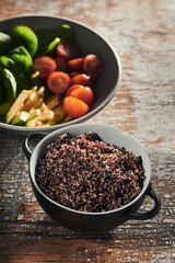 Cooking a vegetarian meal with tomato, avocado, cucumber, basil and quinoa