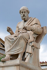 Fototapeta premium the marble statue of the ancient Greek philosopher Plato in front of National Academy of Athens. Cloudy day