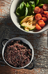 Bowl of soaked quinoa with sprouts and bowl of tomato, avocado and basil