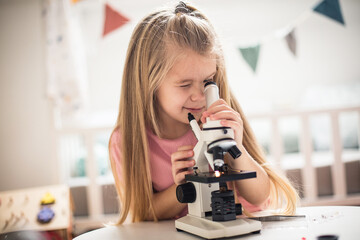 Little girl scientist with microscope.