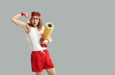 Funny happy man in fitness wear standing against gray free space for text studio background,...