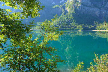 Landscape reflection in the beautiful green natural lake between forests and mountains oft he european Klöntal valley
