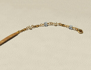 khaki leather strap bracelet with pearl and blue crystal beads on white leather background