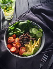 Bowl of quinoa with tomato, cucumber, basil and avocado
