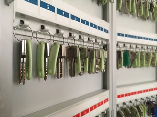 Selective focus of key hanging inside a metal key cabinet. This photo contains noise and grain. 