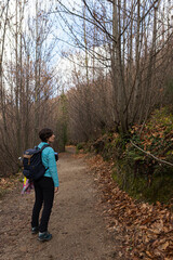 Fototapeta premium Young sporty female hiking up from a valley to the top of a mountain. Athletic young woman walking in the countryside during the winter in Spain.