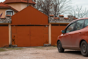 Orange garage gate with orange car parked front of house 