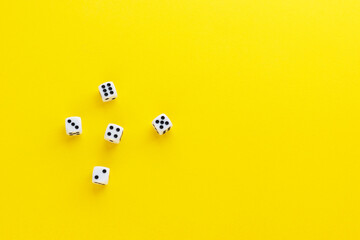 Five dice showing different sides on yellow background. Playing cube with numbers. Items for board games. Flat lay, top view with copy space.