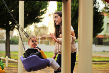 Obraz premium little baby boy playing on playground in outdoor park. Happy Little boy playing seesaw with his sister .Happy moment and good emotion
