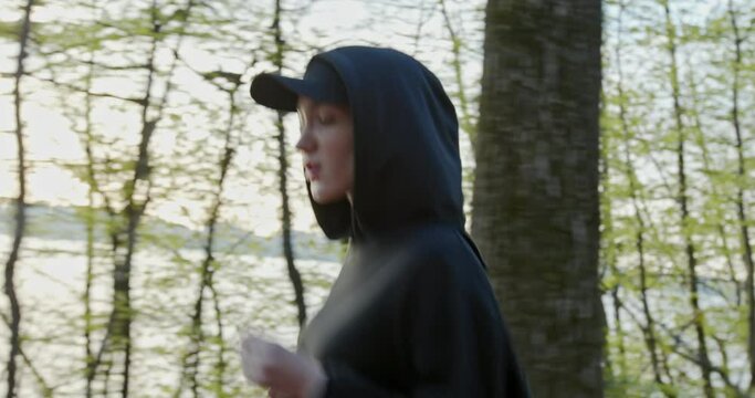 The girl runs strong unbreakable in the woods in sportswear