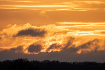 Winter sky at sunset with golden light and dramatic clouds