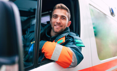 Professional and confident young man doctor looking on the camera with ambulance background © My Ocean studio