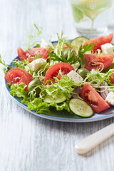 Salad with Green Olives, Tomatoes and Feta Cheese. Bright wooden background. Copy space.	