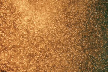 Abstract festive background with selective focus. Bright yellow particles, dark background. Splashes, space energy flow