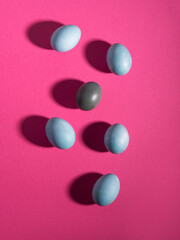 Blue easter hen eggs on dark pink background.