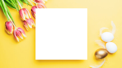 Easter set. Golden, white colour egg in basket with spring tulips, feathers on pastel yellow background in Happy Easter decoration. Traditional design with copy space.