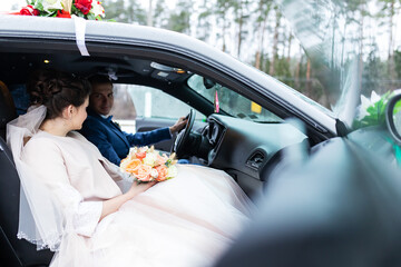 the groom gives his hand to the bride from the car, the politeness and gallantry of people in love, the husband and wife arrived in a decorated car for the wedding