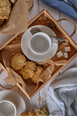 Cup of black coffee and oatmeal cookies with prunes on a wooden tray on a white wooden table