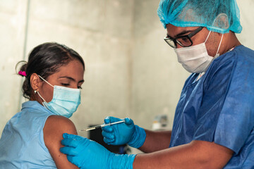 Concept of vaccination and immunization. Hospital nurse injecting a patient. Young woman receiving...