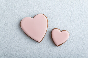 Large and small heart-shaped cookies with icing sugar, white background. Mothers day. Womans day. Valentines day