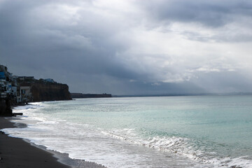stormy sea and sand beach under dark skies in autumn Crimea
