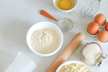 Composition with baking ingredients and cooking utensils on a light background top view