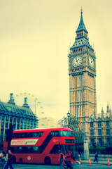 Fototapeta na wymiar Big Ben and blurred red double decker bus, tourists and London Eye. (London, UK). Aged photo.